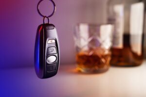 Car keys hanging by a glass of liquor. You can count on a DUI lawyer to assist you following an arrest.