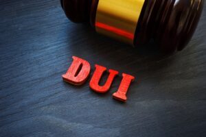 A gavel sitting by letters that spell out DUI. An attorney can explain how much a DUI costs.