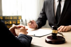 A client consulting a lawyer. Learn about when you should hire a criminal defense lawyer.